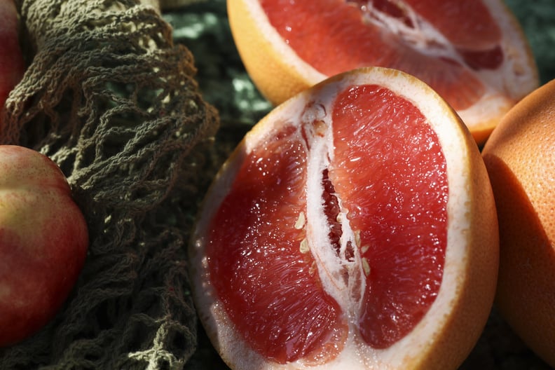Pink peaches and grapefruit in reusable mesh bag.